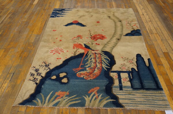 Small scenic pictorial antique chinese bird design baotou area rug 2 Beige scenic rug with blue landscape elements and coral flowers resting on wide plank wood flooring.