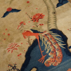 Low-pile tan rug depicting a stylized coral bird and blue scenery on wood plank flooring.