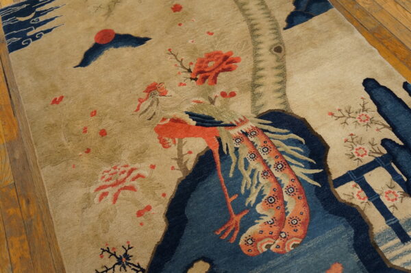 Small scenic pictorial antique chinese bird design baotou area rug 6 Low-pile tan rug depicting a stylized coral bird and blue scenery on wood plank flooring.