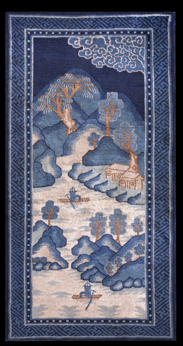High-pile rug in indigo and beige featuring a mountain and water landscape with a detailed geometric border.