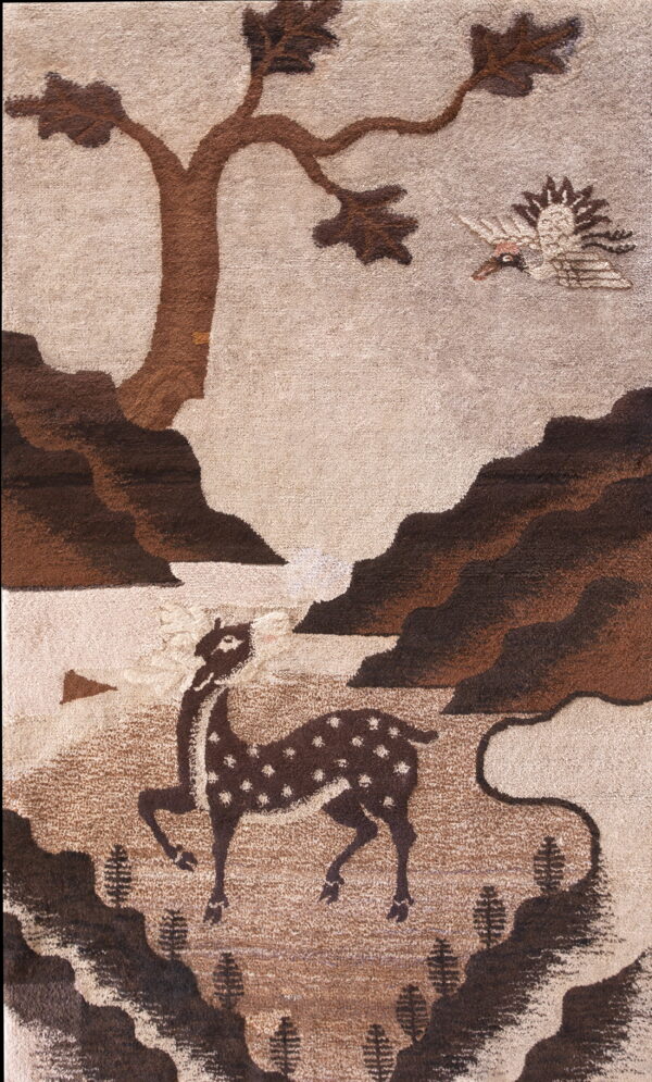 Sculpted pile rug in brown and taupe with a forest scene featuring a deer, tree, and bird.