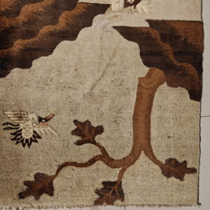 Beige and brown pictorial rug featuring a tree branch and flying bird motif on light tiled flooring.