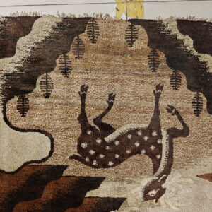 A shaggy brown and tan rug featuring a stylized deer pattern sits on white tiled floor.