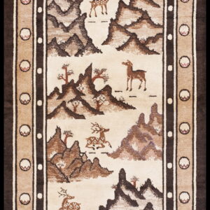Ivory and brown pictorial rug depicting deer, a bird, and mountains, surrounded by a complex geometric border.