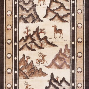 Beige and dark brown rug showing a scenic landscape of stylized mountains, deer, and trees.