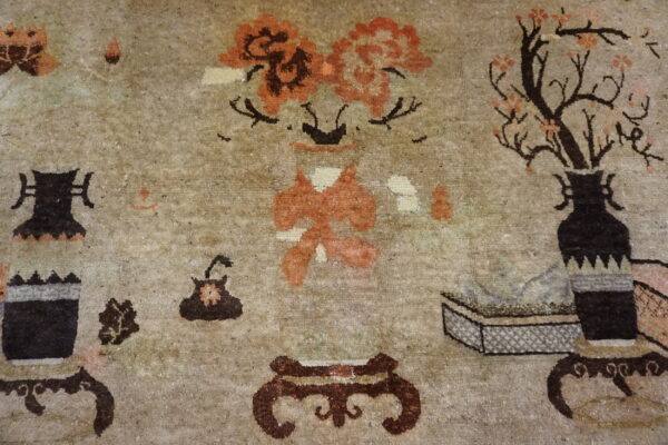 Muted beige rug with detailed dark brown vessels, orange blossoms, and stylized floral patterns.