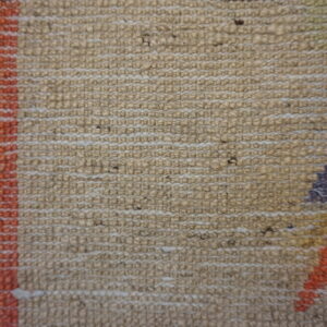 Knobby textured rug close-up featuring beige weave, dark stripes, and geometric patterns in orange and purple.