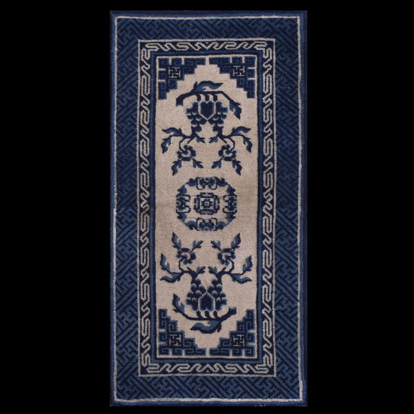 Narrow blue and beige runner rug with a central floral design and thick geometric borders.