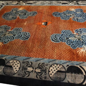 Rust-red patterned rug featuring four large blue cloud and phoenix motifs with an elaborate abstract border.