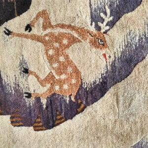 Textured rug close-up featuring a brown spotted fawn jumping over abstract beige and dark mauve elements.