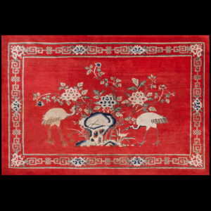 The red rug features white cranes and floral motifs with a detailed grey and blue geometric border.