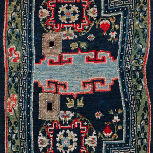 Intricate red and navy rug featuring a stepped edge, geometric patterns, and a central cream and blue field.