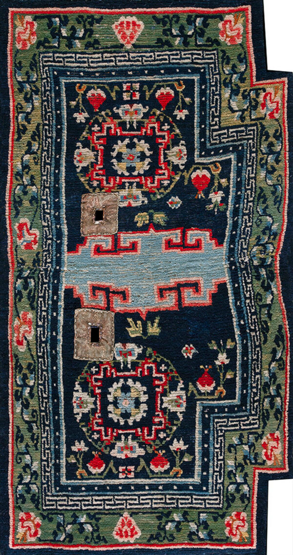 Intricate red and navy rug featuring a stepped edge, geometric patterns, and a central cream and blue field.