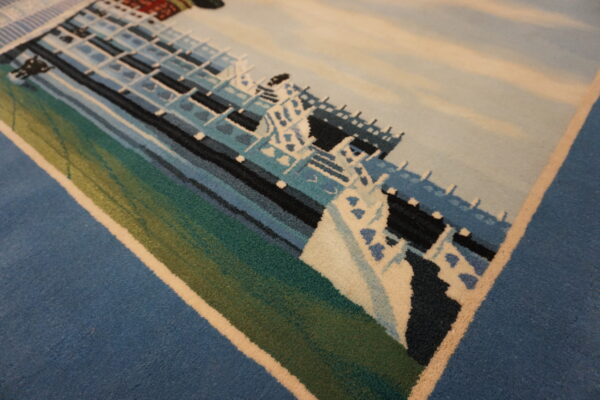 Pictorial low-pile rug featuring a large ship design rendered in blues, white, teal, and green colors.