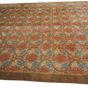Low-pile rug with a repeating floral pattern in rust, teal, and gold, framed by a wide dark brown border.