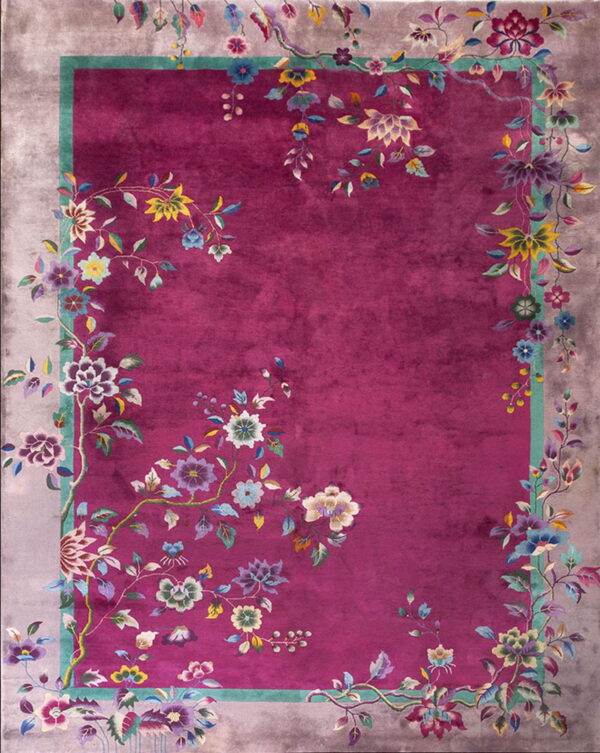 Plush magenta rug featuring multicolored vines and flowers sprawling across the field and a grey border.