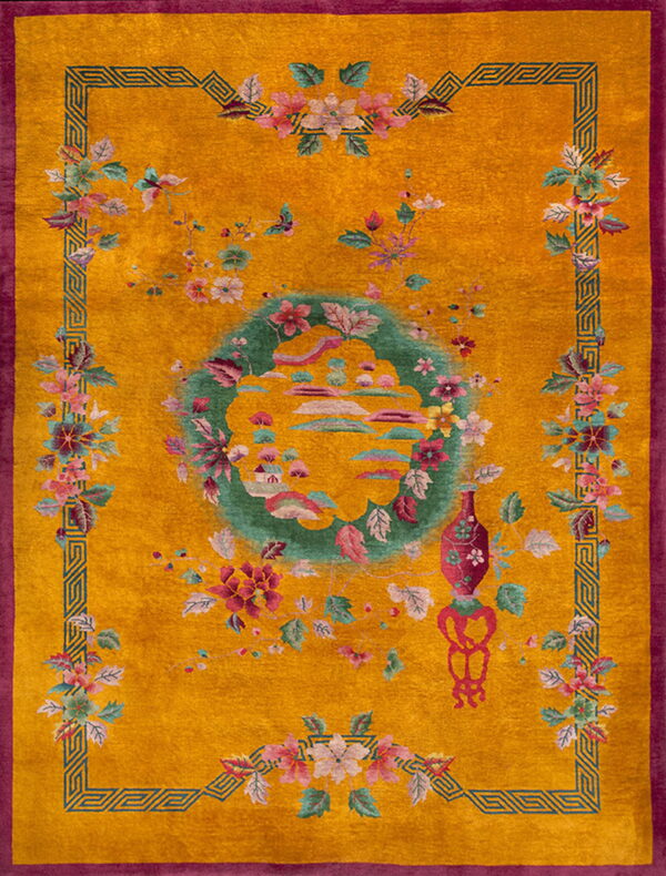 Plush gold rug with a magenta border, teal geometric trim, and scattered pink and green floral designs.