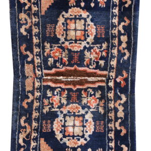 Stepped dark blue runner rug featuring formal peach and tan patterned borders and central motifs.