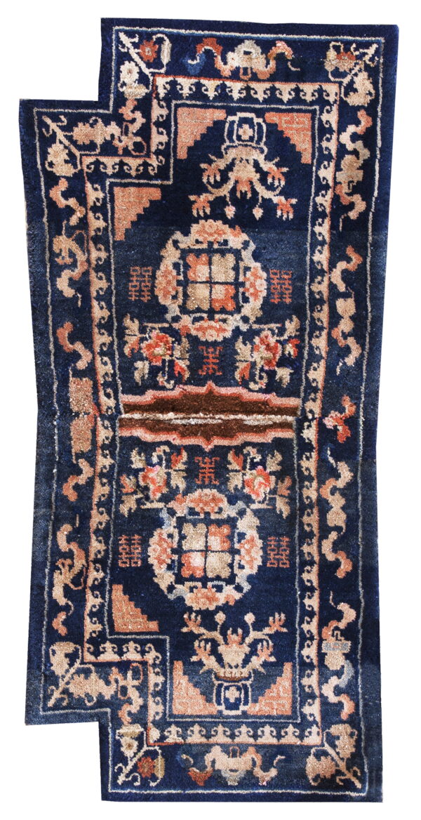 Stepped dark blue runner rug featuring formal peach and tan patterned borders and central motifs.