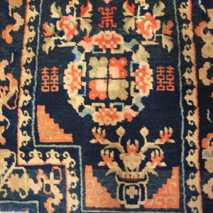 Navy blue rug section with stylized floral and geometric patterns in coral, tan, and light blue.