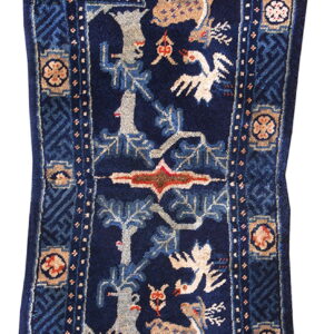Pictorial dark blue stepped rug with beige deer, white birds, gray trees, and complex geometric borders.
