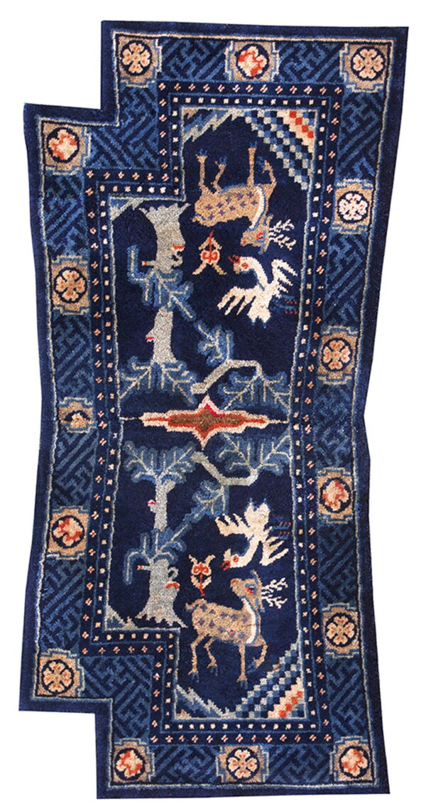 Pictorial dark blue stepped rug with beige deer, white birds, gray trees, and complex geometric borders.