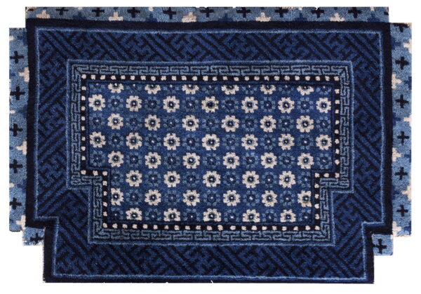 Dark blue rug featuring a white floral center field framed by stepped geometric borders.