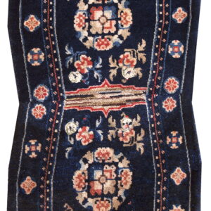 Dark blue figural rug with stylized floral designs in terracotta, beige, and light blue.