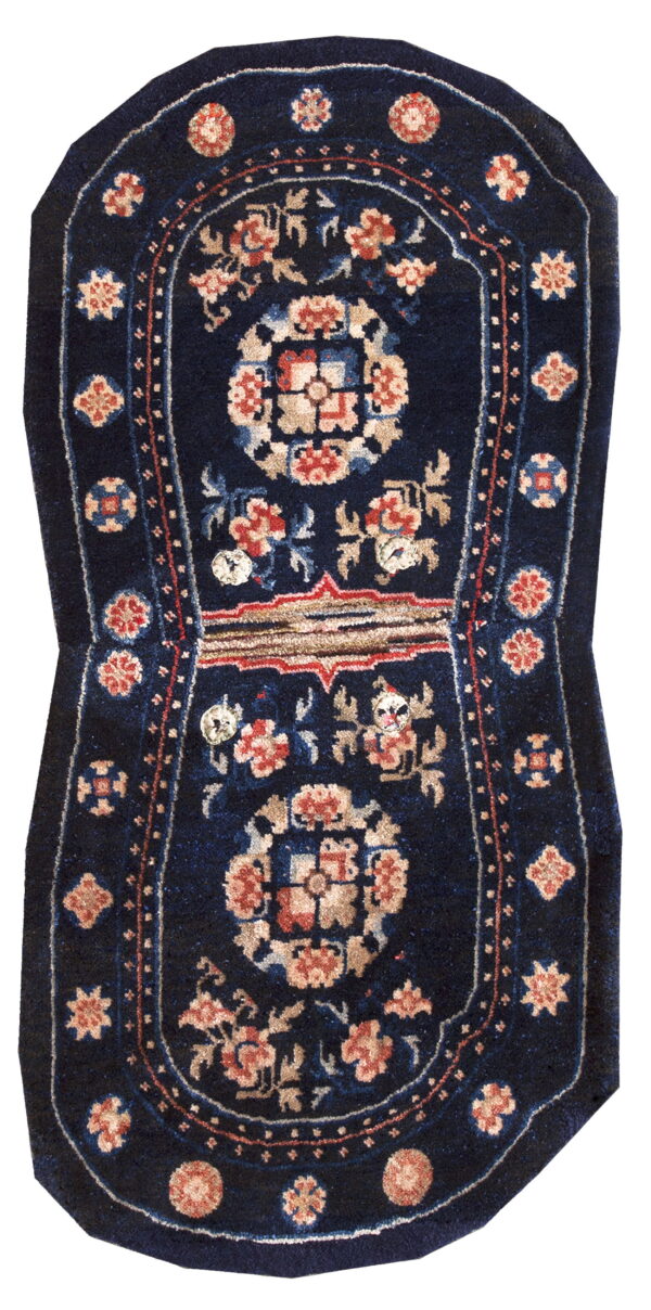 Dark blue figural rug with stylized floral designs in terracotta, beige, and light blue.