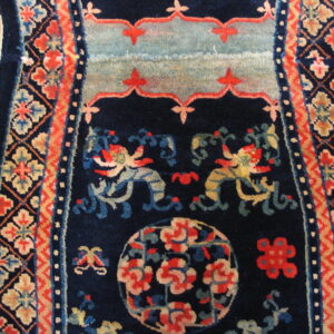 Navy rug detail showing stylized dragons, floral medallions, and geometric borders on hardwood flooring.