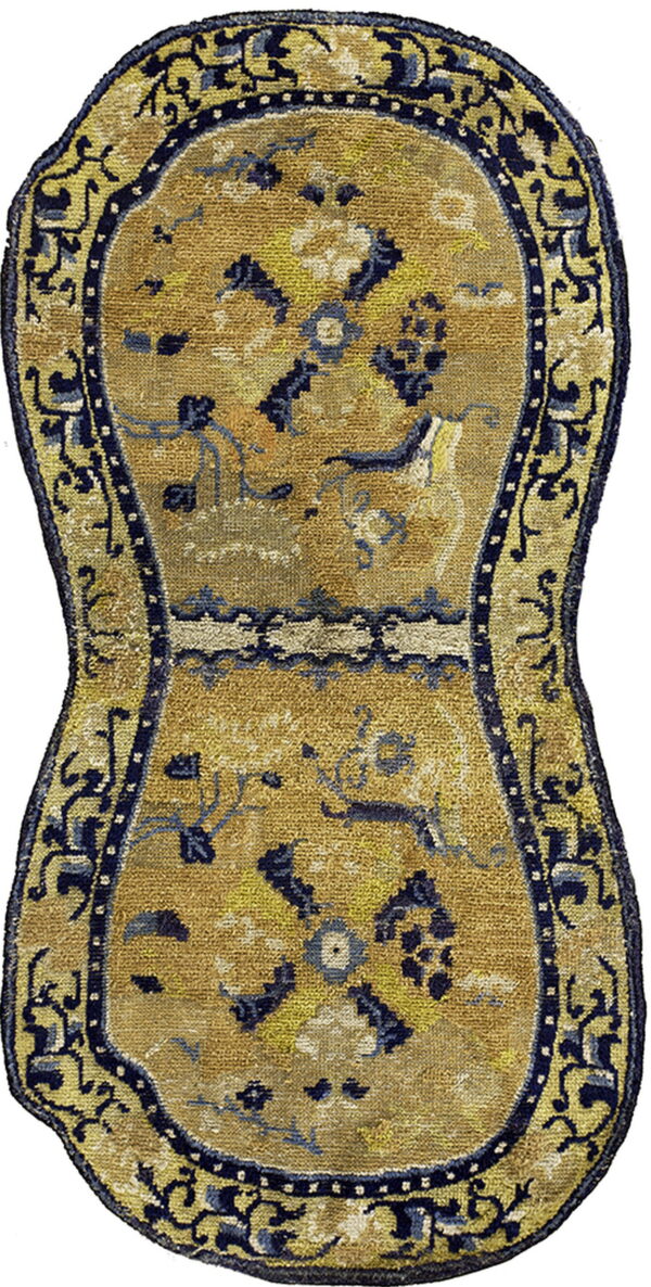 Hourglass-shaped rug with a gold center, blue and yellow floral motifs, and a dark blue curved border.