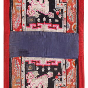 Red, black, and orange textile with complex mythical animal patterns divided by a wide indigo band.