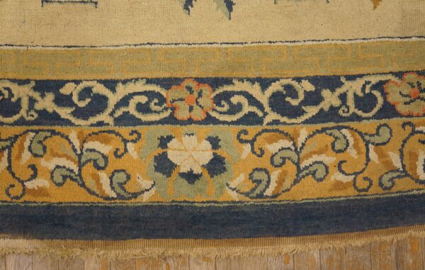 Floral and geometric borders in mustard, navy, and beige resting on light rustic wood floor.