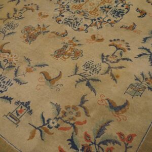 Beige rug featuring a detailed traditional pattern of navy, rust, and teal floral elements and a scrolled border.