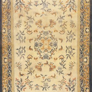 Cream rug featuring navy and ochre floral designs surrounded by a multi-layered scrolling border.