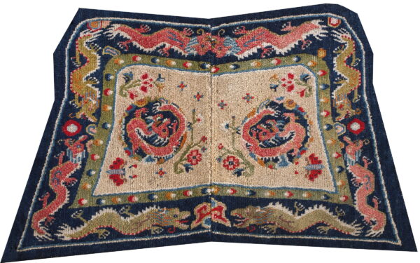 Navy blue and tan rug with symmetrical coral dragon patterns and a richly detailed multicolor border.
