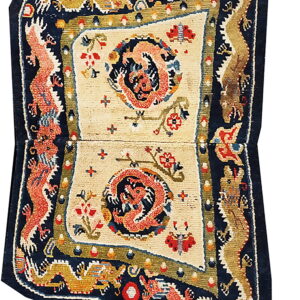 A cream and navy rug featuring coiled red and gold dragon motifs within detailed medallions and borders.