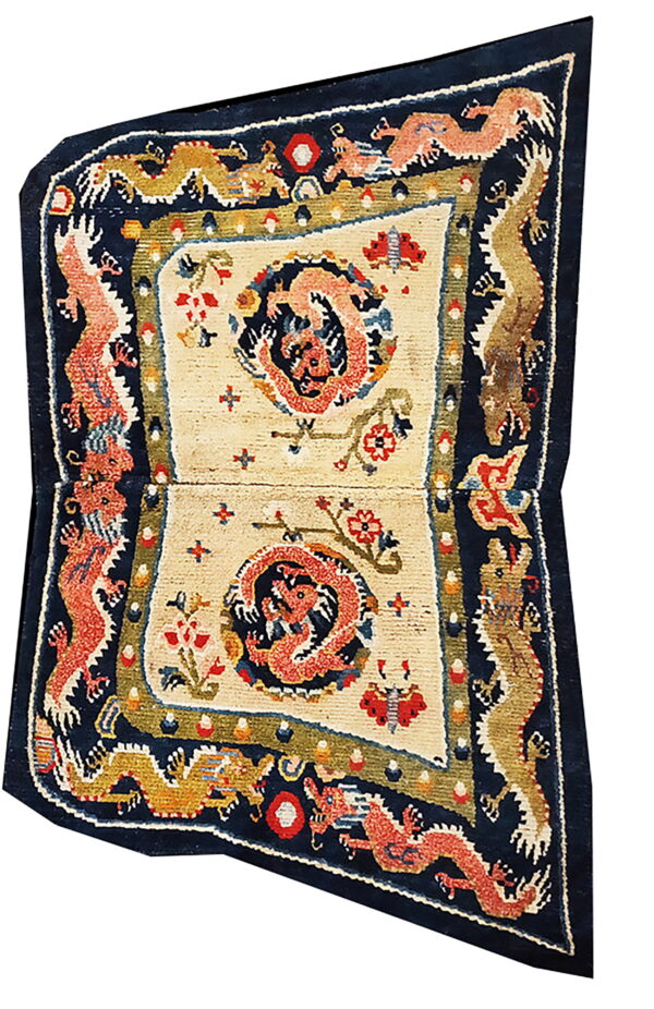 A cream and navy rug featuring coiled red and gold dragon motifs within detailed medallions and borders.