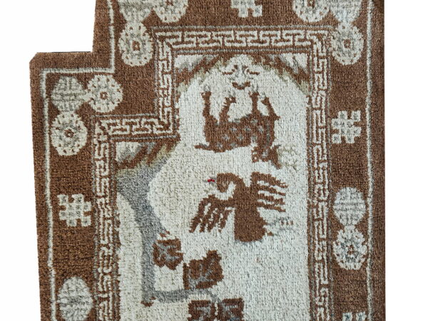 Shaggy brown and cream rug detail showing animal motifs framed by geometric borders.