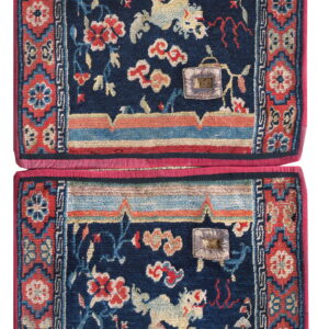 A pair of stacked navy mats featuring red floral patterns, mythological animals, and geometric red borders.