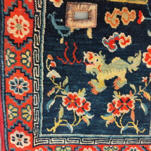 Textured navy blue rug displaying a yellow dragon, red flowers, and ornate patterned borders.