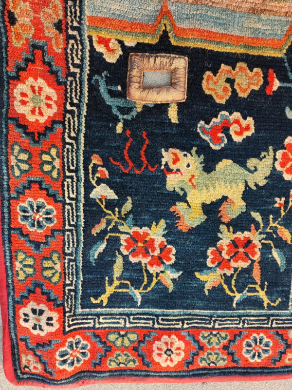 Textured navy blue rug displaying a yellow dragon, red flowers, and ornate patterned borders.