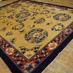 Yellow rug featuring scattered blue cloud and floral motifs, bordered by navy and rust red bands on wood floors.