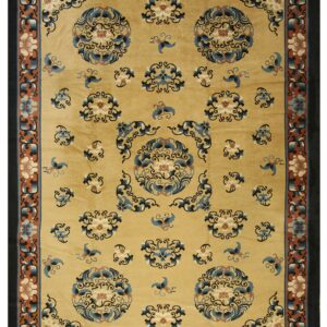 Ornate golden-beige rug featuring large blue and cream floral medallions framed by a complex black and rust border.