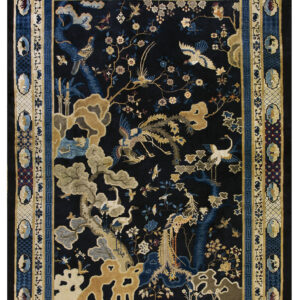 The black field of this rug holds a detailed gold and blue pattern of birds, trees, and landscape motifs.