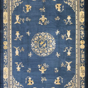 Deep blue rug with an intricate gold pattern featuring a central medallion and scattered vases.