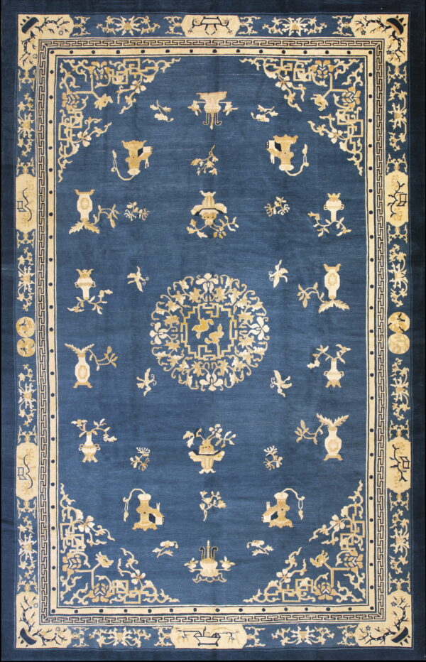 Deep blue rug with an intricate gold pattern featuring a central medallion and scattered vases.