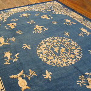 Low-pile blue rug with an ornate cream medallion and scattered light floral patterns on rustic wood planks.
