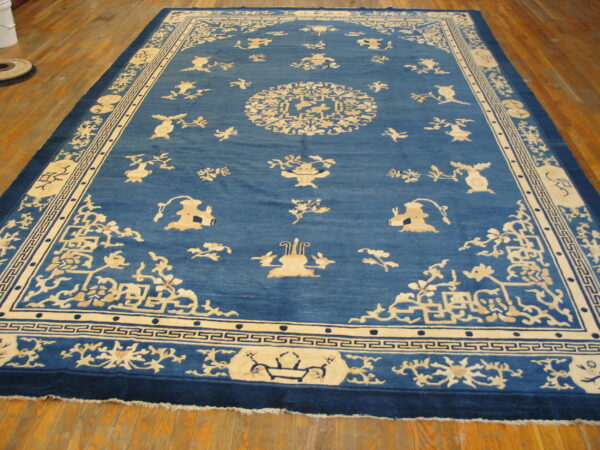 Blue rug with detailed cream traditional patterns and borders lies on hardwood flooring.