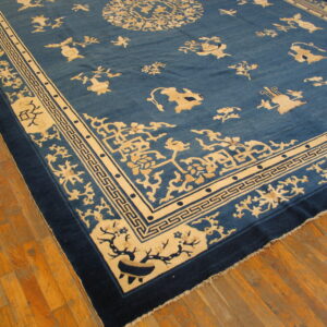 Low pile rug in deep blue and cream with stylized animals and geometric borders on hardwood flooring.